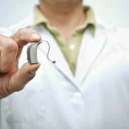 Hearing specialist holds hearing aid