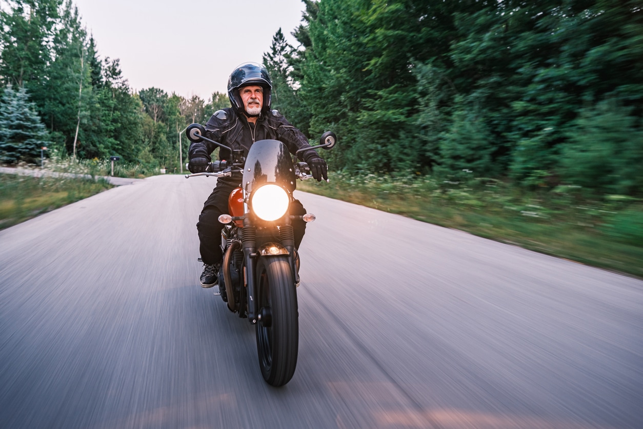 Man riding his motorbike in the countryside at dawn.