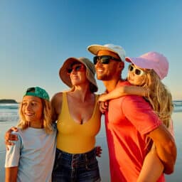 Happy family enjoying beach vacations at sunset