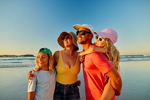 Happy family enjoying beach vacations at sunset.